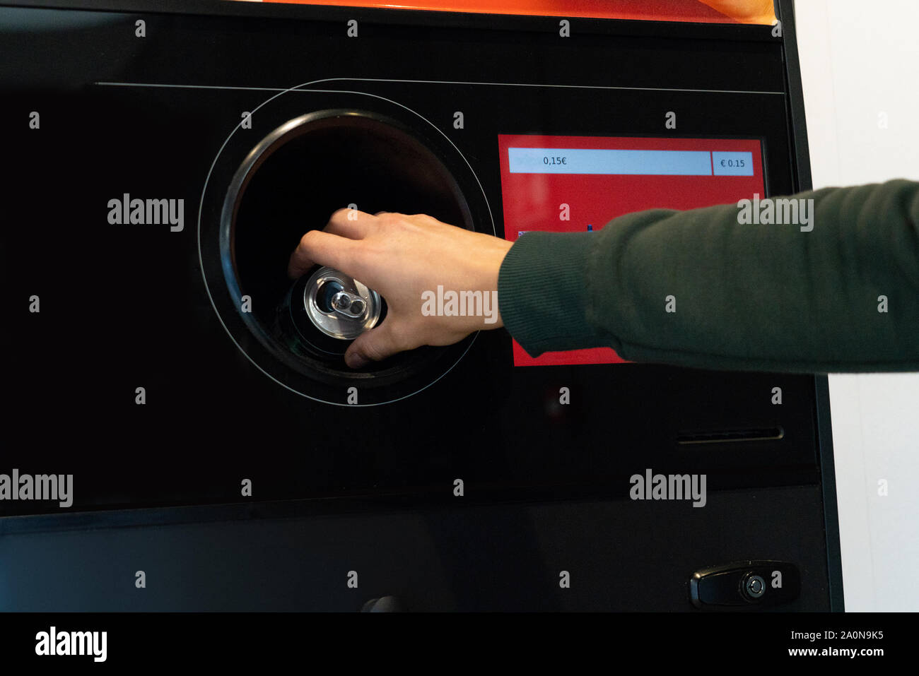 L'uomo utilizza un self service per ricevere bottiglie di plastica usate e lattine in un negozio Foto Stock