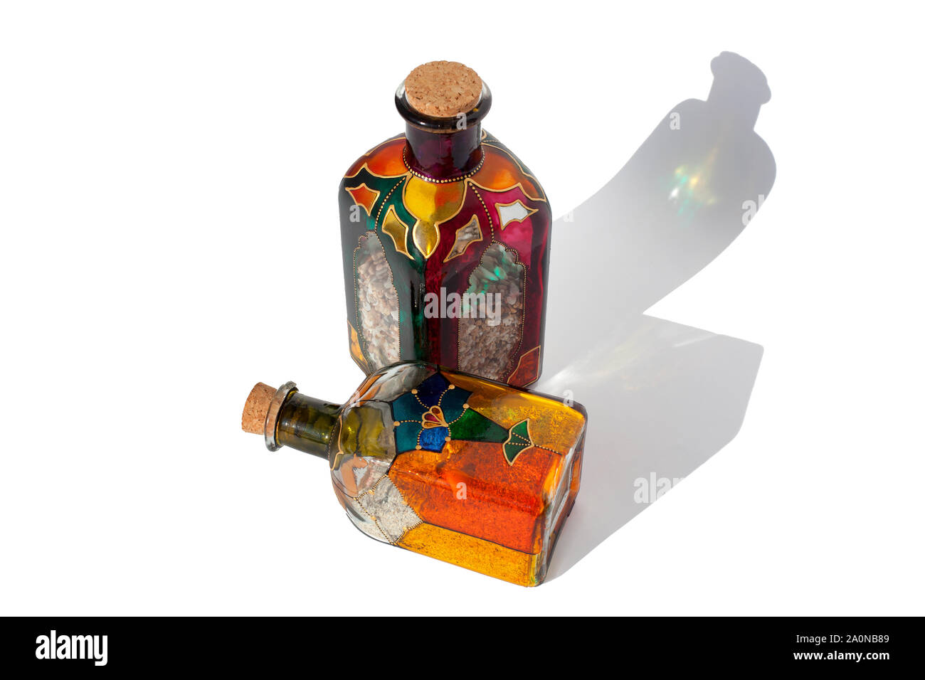 Colorate le bottiglie di vetro con sabbia all'interno su sfondo bianco isolato Foto Stock