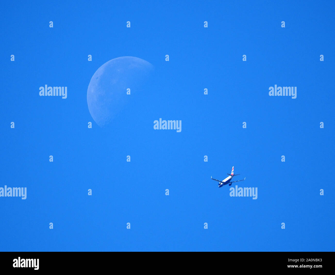 Sheerness, Kent, Regno Unito. Il 21 settembre, 2019. Regno Unito: Meteo a British Airways vola a getto sotto il " terzo trimestre" (noto anche come ultimo trimestre) luna visto mettere in chiaro cielo blu su Sheerness, Kent oggi. Il terzo quarto di luna è quando la metà opposta della luna è illuminata rispetto al primo trimestre. Credito: James Bell/Alamy Live News Foto Stock