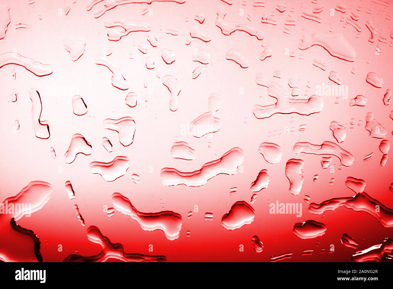 Gocce d'acqua sul vetro della superficie a specchio in colore rosso luce gradiente, liquido di sfocatura blot texture di sfondo, sanguinosa pattern vista da vicino Foto Stock