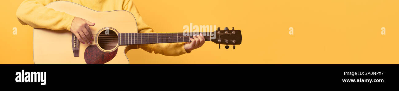 Chitarra in mani su sfondo giallo, panoramica mock up immagine Foto Stock