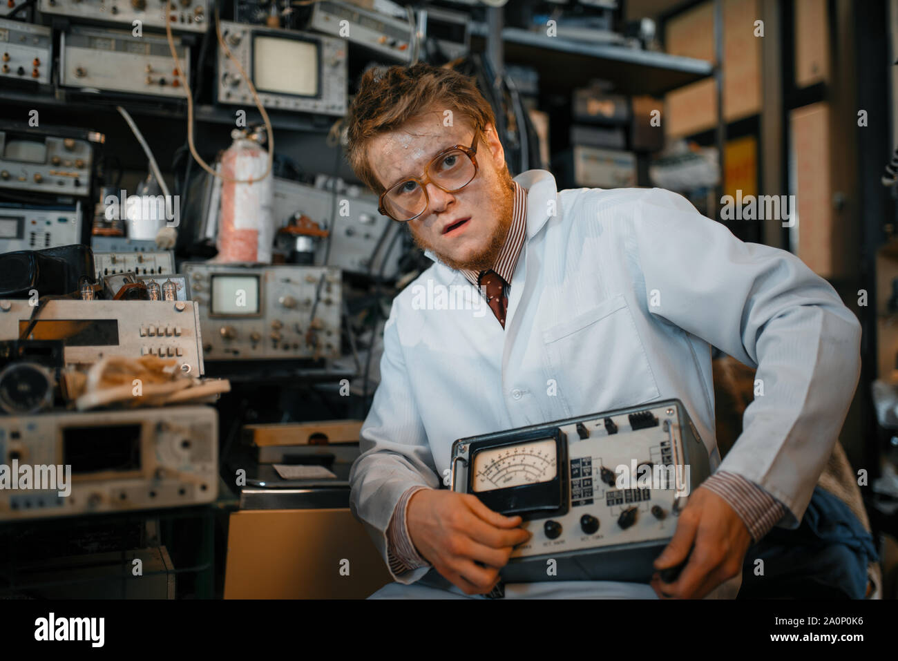 Lo scienziato pazzo detiene il dispositivo elettrico in lab Foto Stock