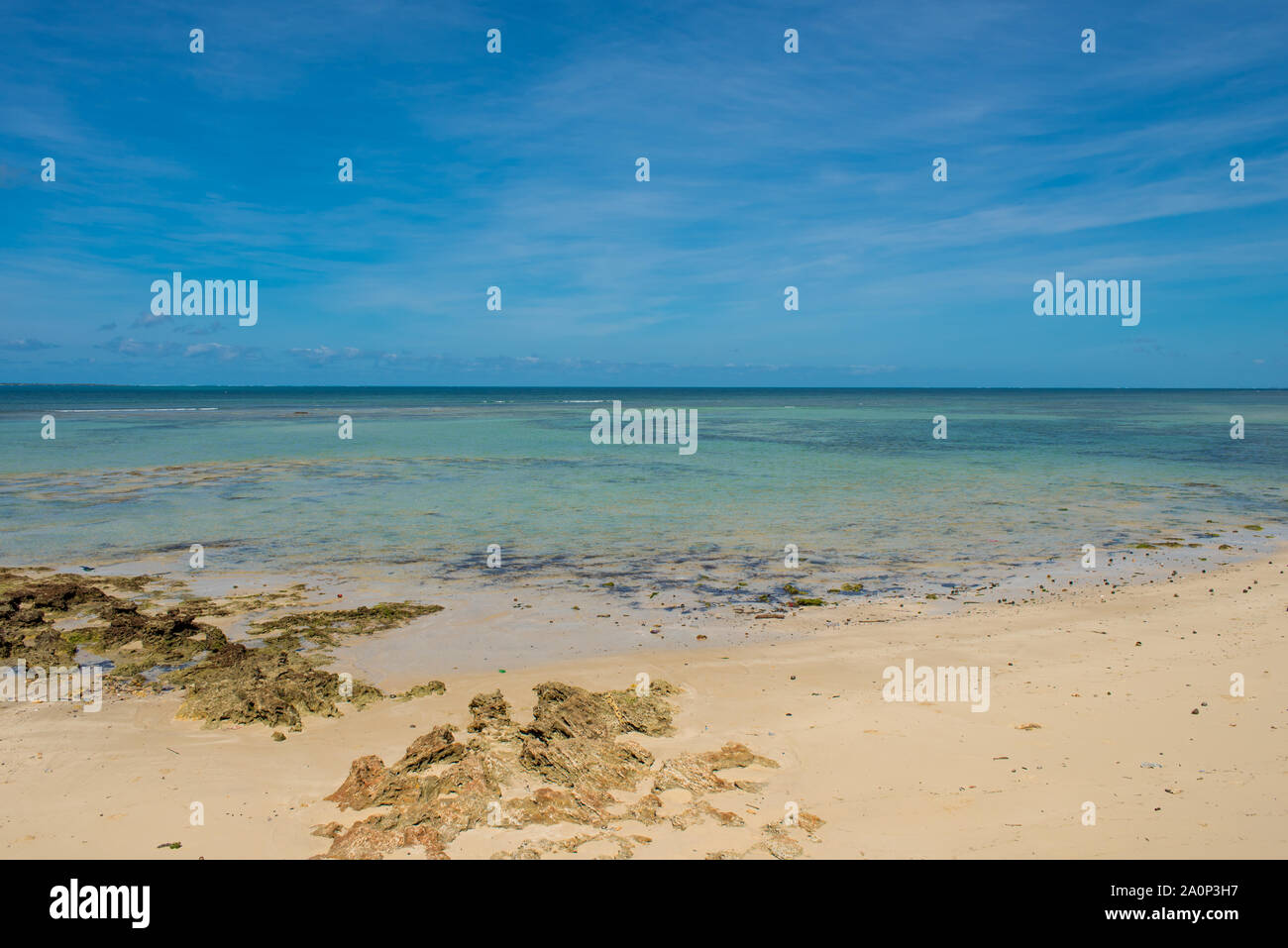 Un vuoto di spiaggia bianca e poco profonde acque turchesi sotto un sole cielo blu sull'Isola di Mozambico (Ilha de Mocambique). Nampula Provincia, Mozambico Foto Stock