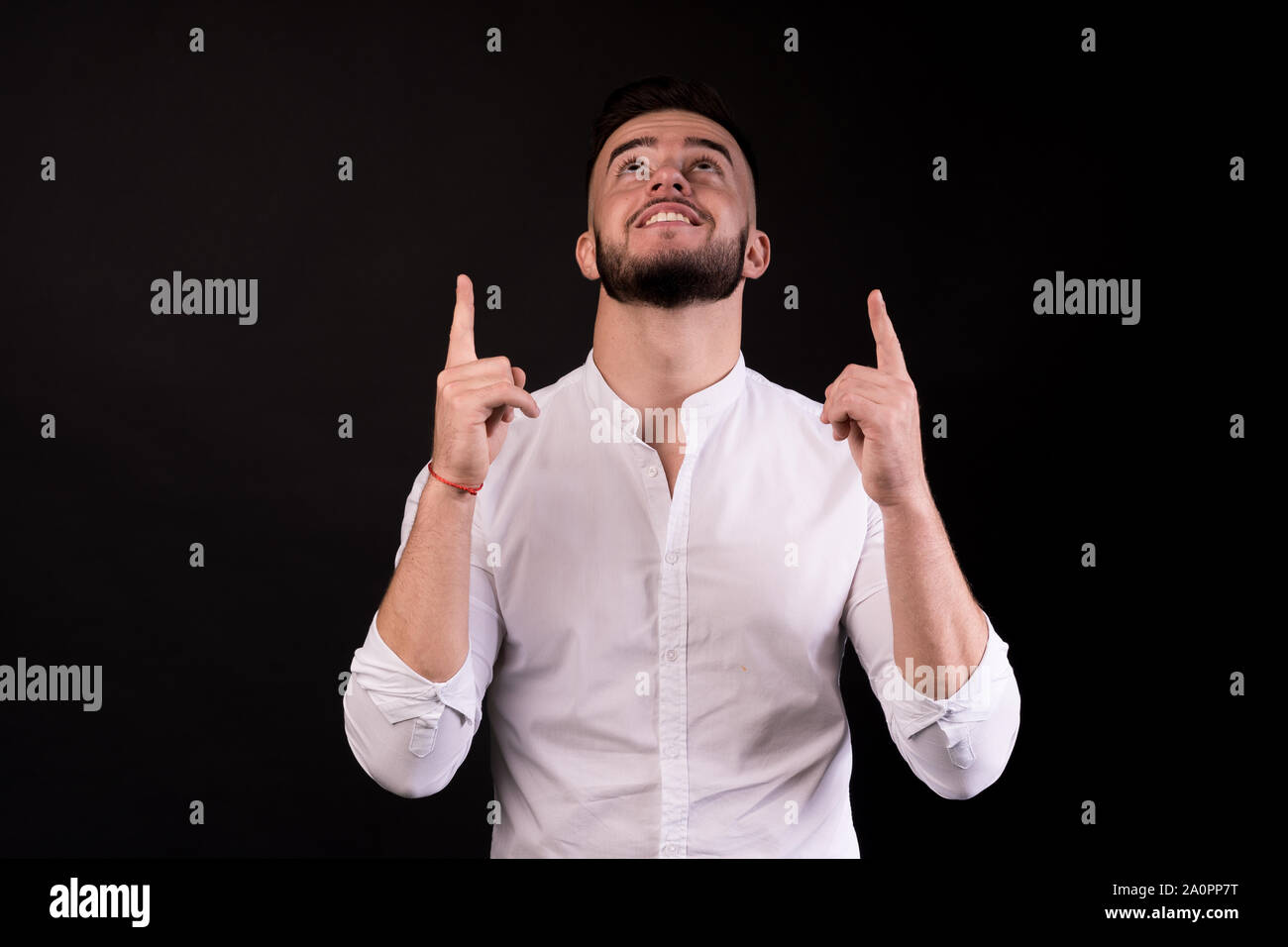 Executive a guardare in alto e rivolto verso il isolati su nero. Camicia bianca, i punti verso l'alto. L'uomo guarda in alto. Foto Stock Executive a guardare in alto e rivolto verso il isolati su nero. Camicia bianca, i punti verso l'alto. L'uomo guarda in alto. Foto Stock