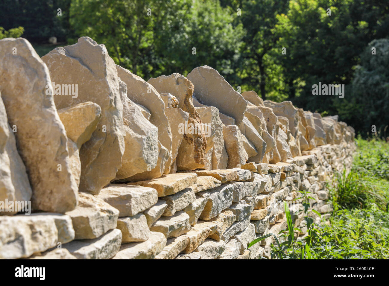 Un Cotswold secco muro di pietra nel processo di costruzione. Un paesaggio tradizionale artigianale specialità Foto Stock