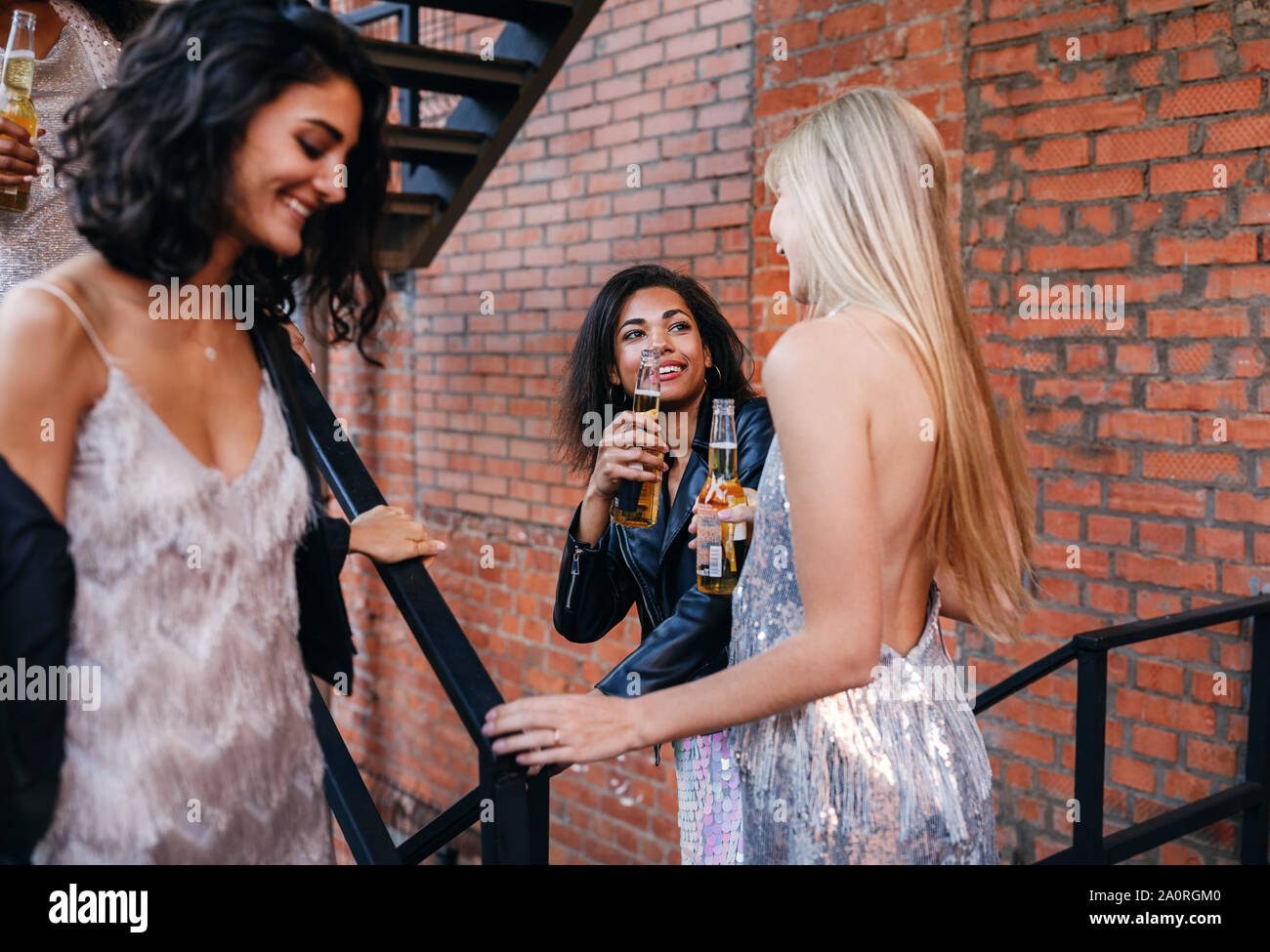 Due donne birre di tostatura mentre andando giù per le scale nella città Foto Stock
