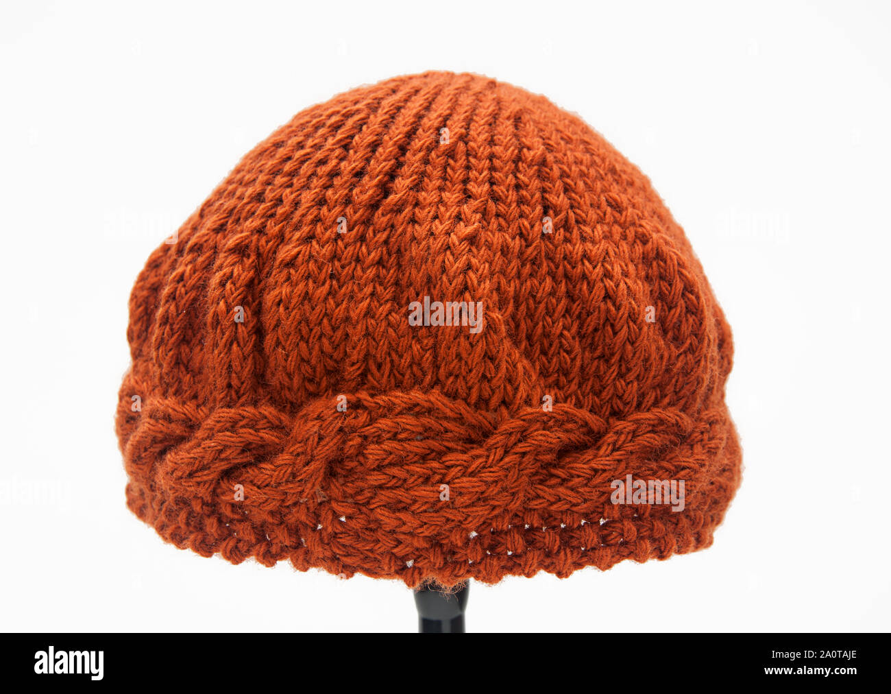 Colore di zucca berretto lavorato a maglia per donna con cuciture cablati attorno all'orlo in questo accessorio di moda per autunno e inverno, isolata su uno sfondo luminoso Foto Stock