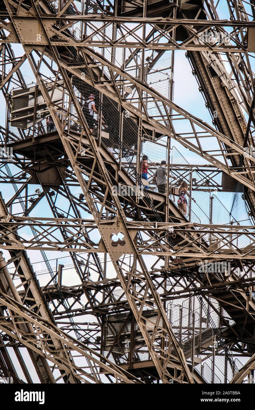 I turisti a piedi giù per le scale all'interno di sbagliato serramenti in ferro della Torre Eiffel a Parigi Foto Stock