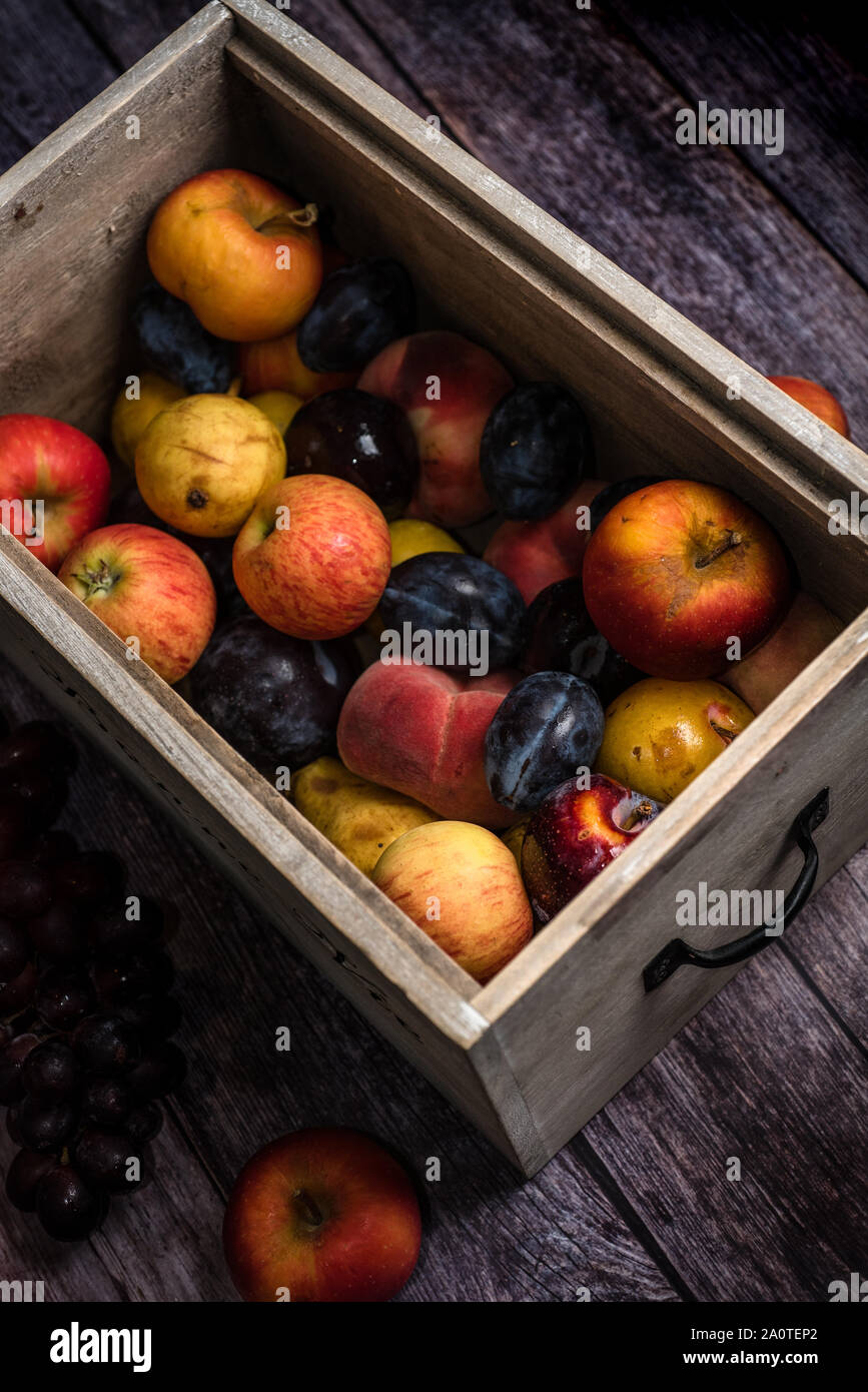 Cassetta di frutta in scatola con un assortimento di carni di colture e di produzione Foto Stock