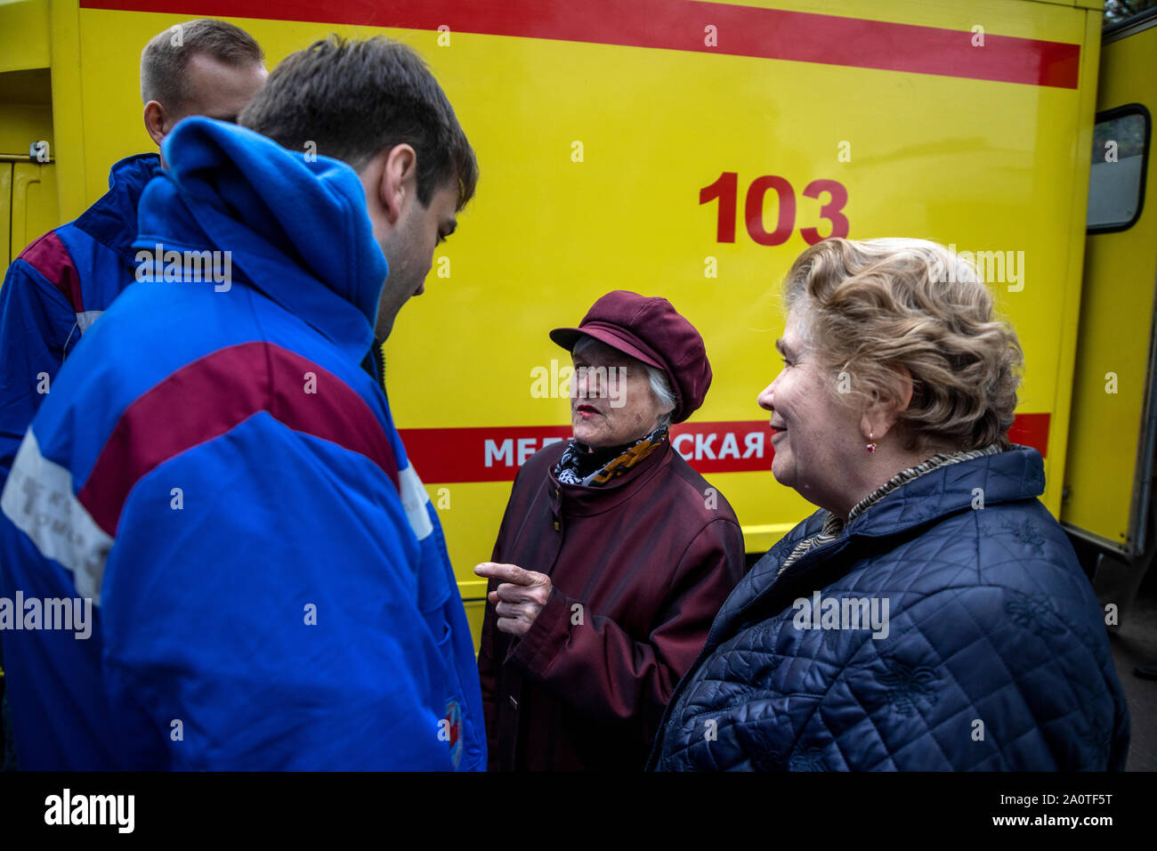Un team di emergenza medica medici parlare con donne anziane in background di una ambulanza a Mosca, Russia Foto Stock