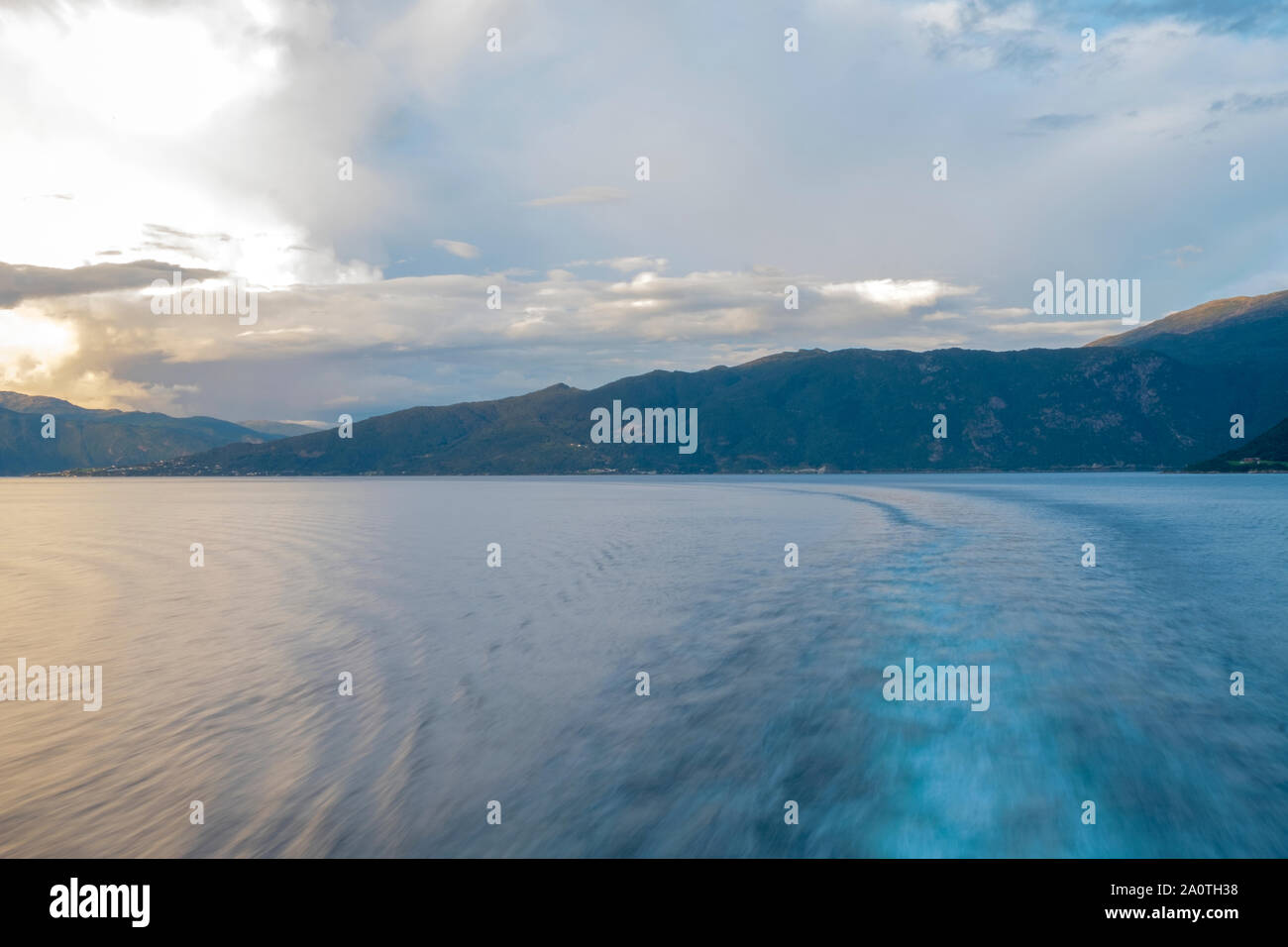 Queen Mary 2's wake attraverso ancora un fiordo Norwgian al tramonto Foto Stock