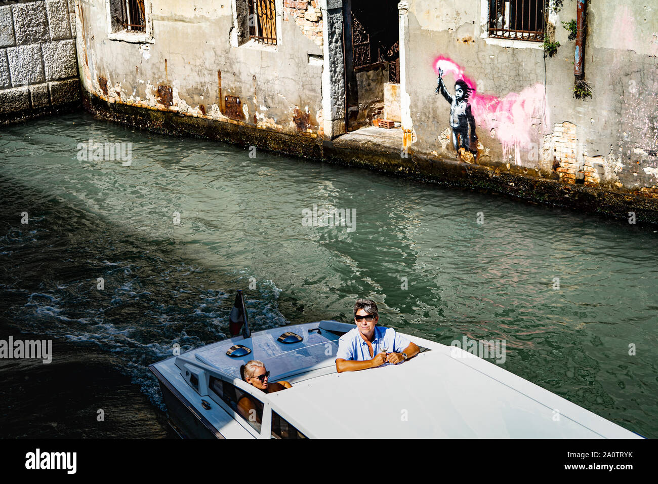 Banksy "migranti bambino', murale / graffiti / arte, quartiere di Dorsoduro, Venezia, Italia con passaggio in barca Foto Stock