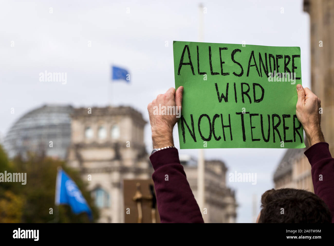 Berlino, Germania 9/20/2019 Un uomo detiene un verde segno di protesta sopra la sua testa che legge in tedesco TUTTO IL RESTO DIVENTA ANCORA PIÙ COSTOSO. Il tedesco par Foto Stock