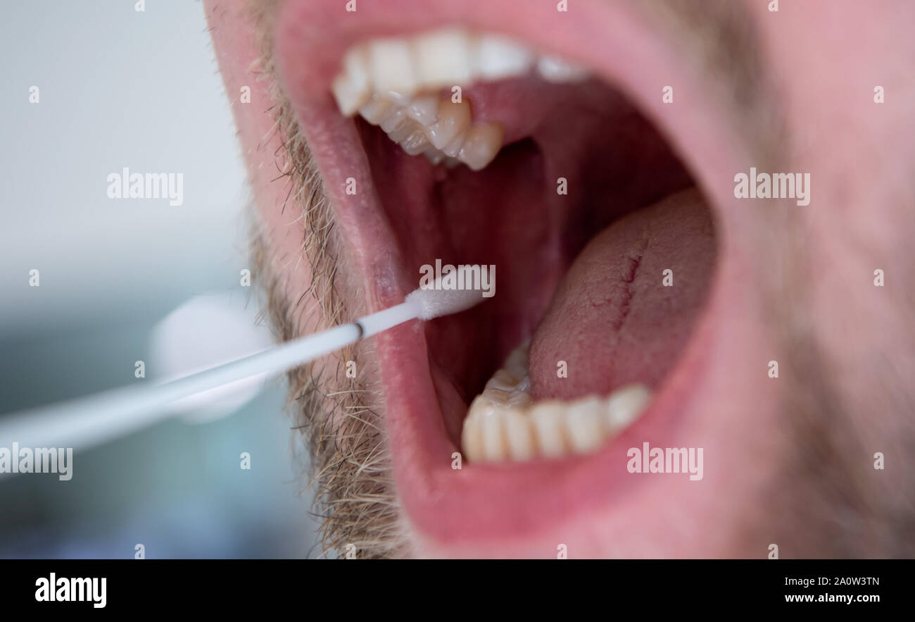 Monaco di Baviera, Germania. 26 Ago, 2019. Un uomo utilizza un tampone di cotone per prendere la mucosa orale di cellule per un campione di DNA. Credito: Sven Hoppe/dpa/Alamy Live News Foto Stock