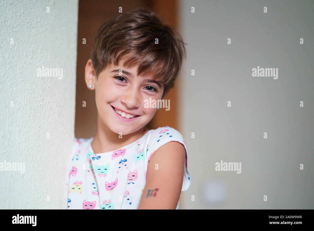 Adorabile bambina di otto anni, fissando sorridere alla telecamera. Foto Stock