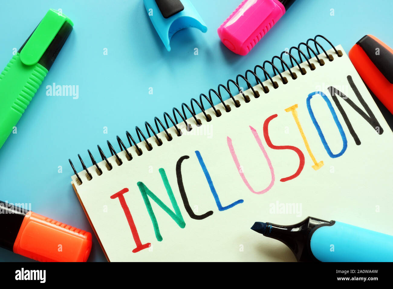 Istruzione di inclusione nozione. Notebook e marcatori colorati. Foto Stock