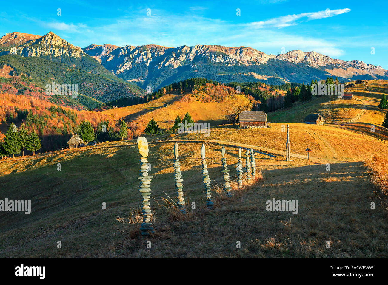 Pittoresca autunnale colorato paesaggio di campagna con rurale capanne in legno e le alte montagne sullo sfondo, crusca, Transilvania, Romania, Europa Foto Stock