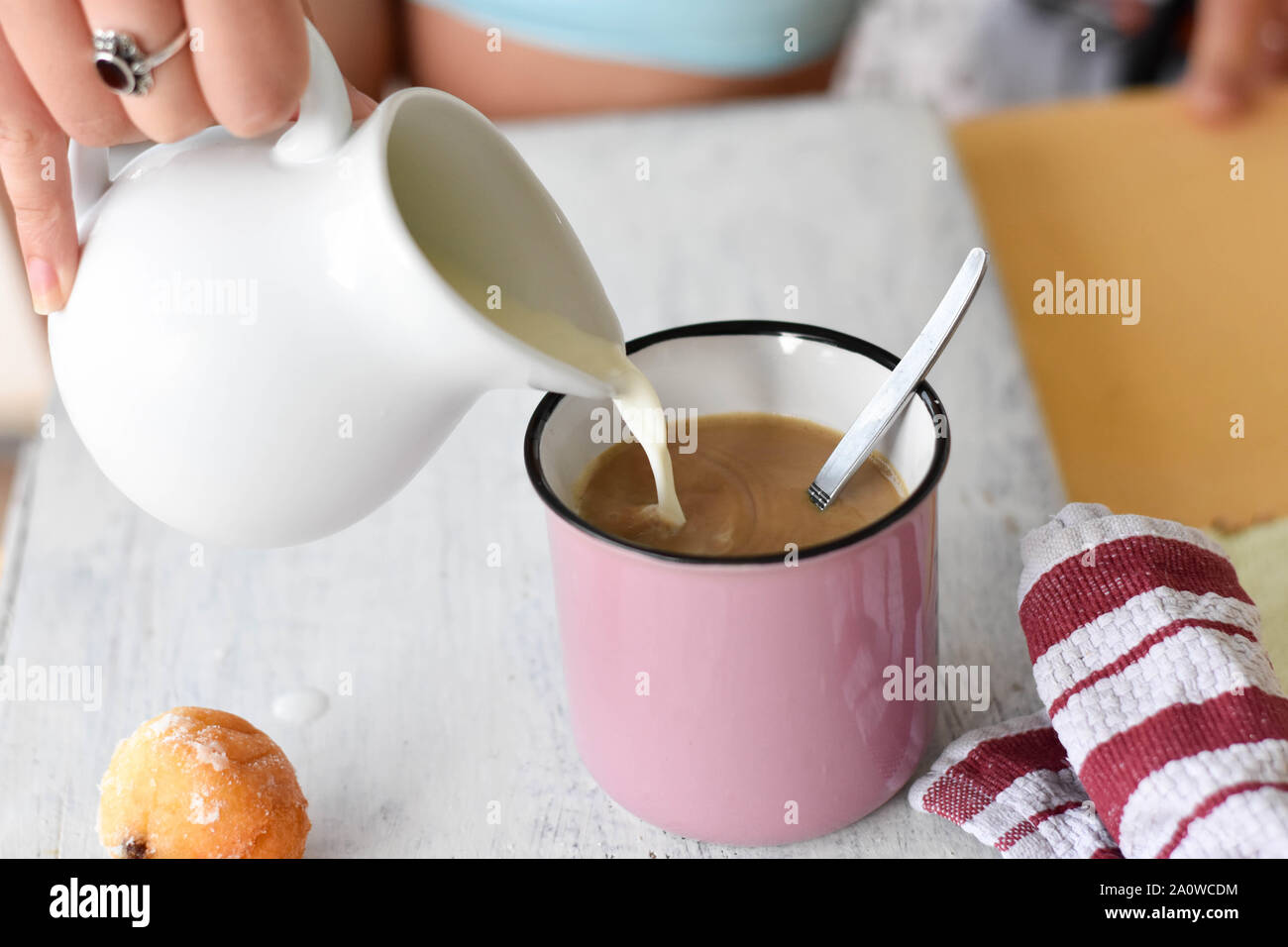 Il caffè e il latte sulla tavola. Versare il latte nel caffè/cappuccino/ tavolo per la prima colazione a partire da un giorno - Immagine Foto Stock