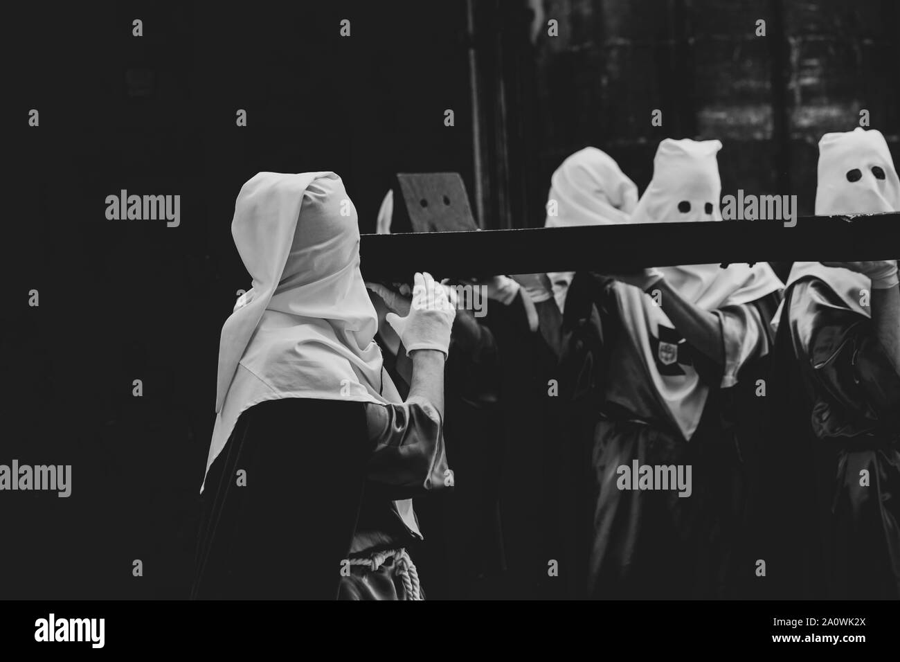 Membri della confraternita che tiene la croce Foto Stock