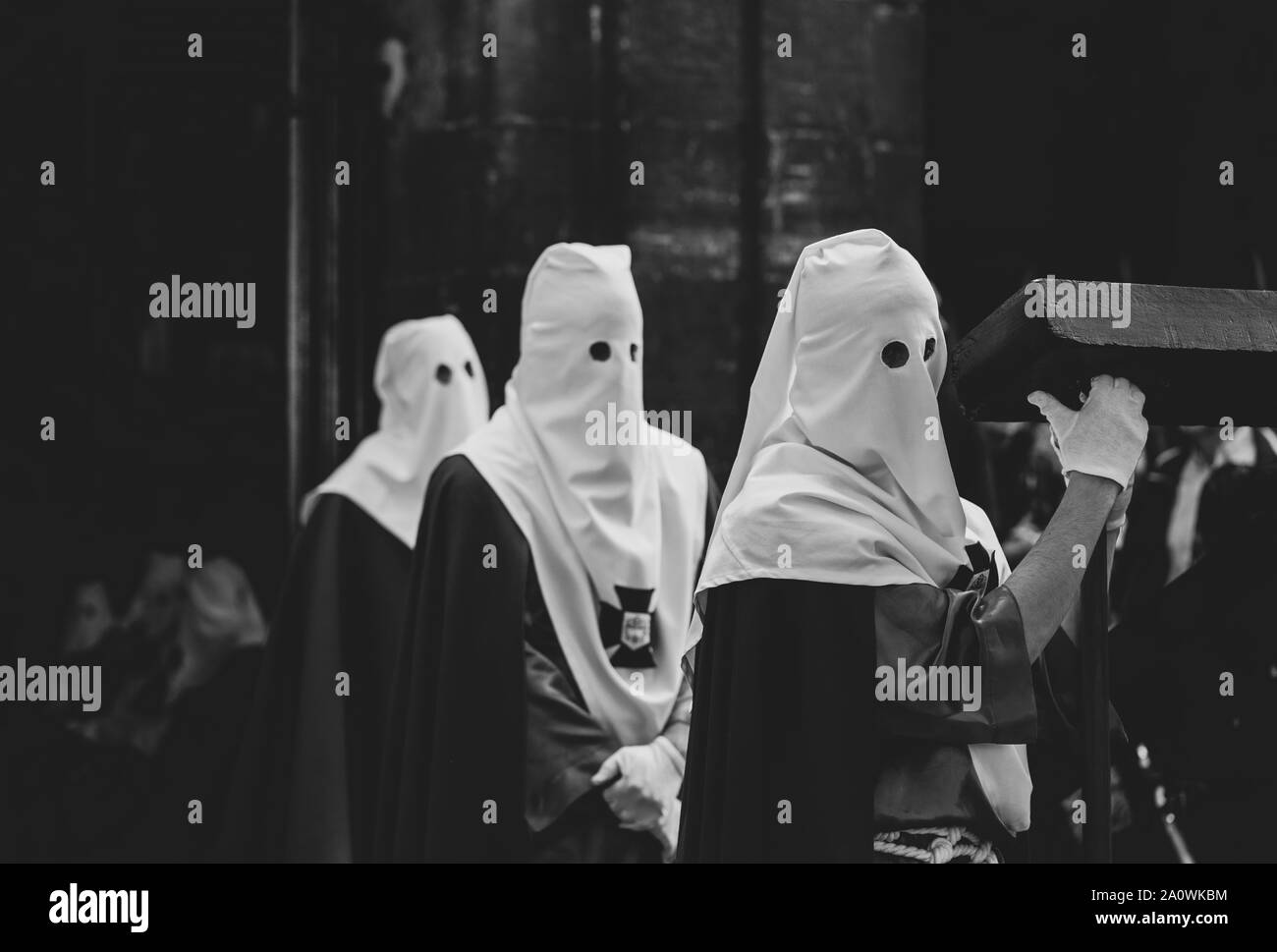 Membri della confraternita che tiene la croce Foto Stock