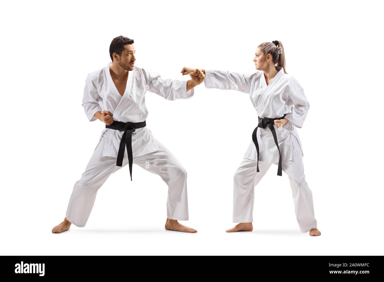 A piena lunghezza shot di un uomo e di una donna con cinture nere nel karate lotta isolata su sfondo bianco Foto Stock