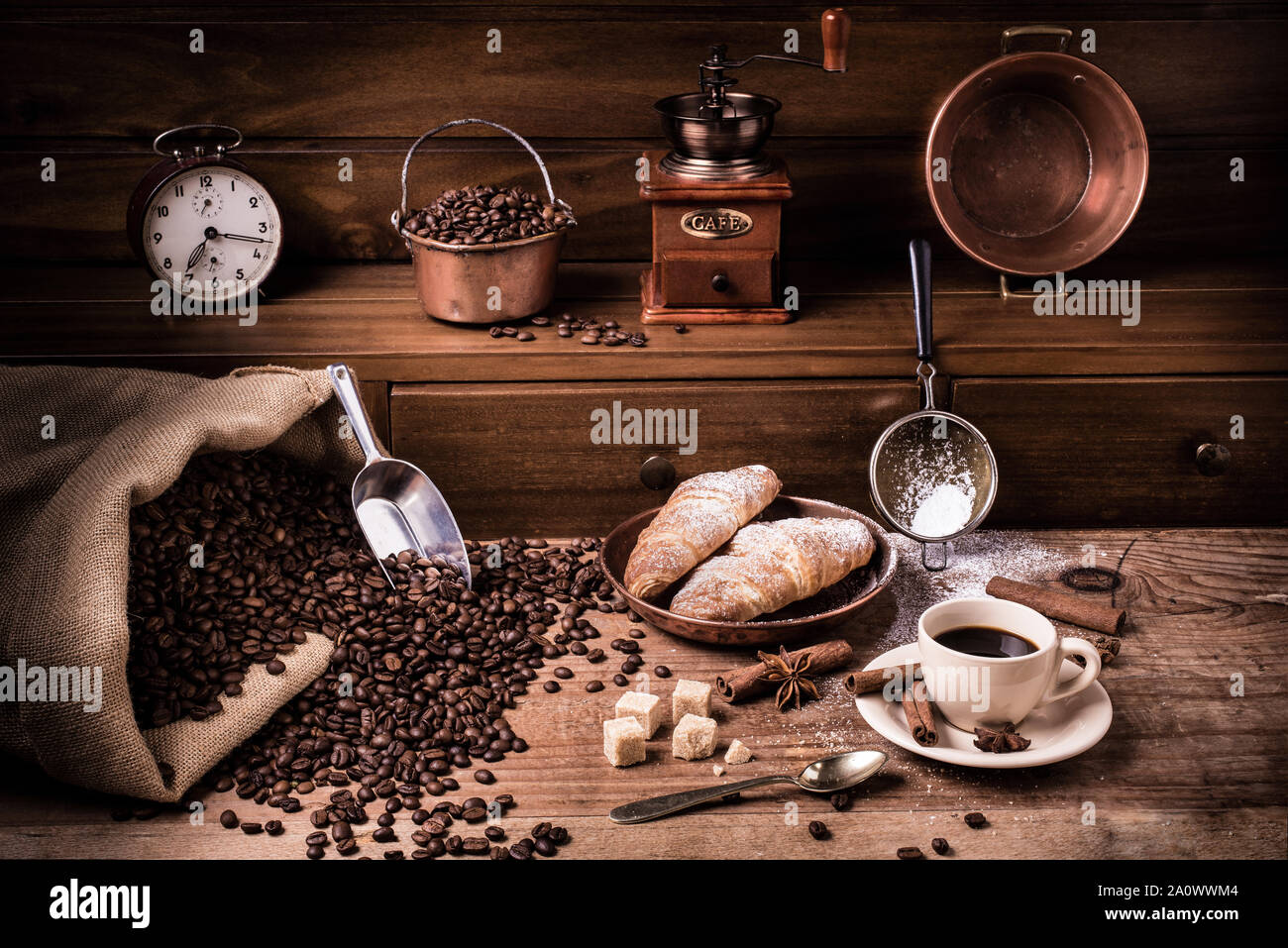 Colazione casalinga con una tazza di caffè nero dolcificata con zucchero di canna e cornetti caldi.Still Life Foto Stock