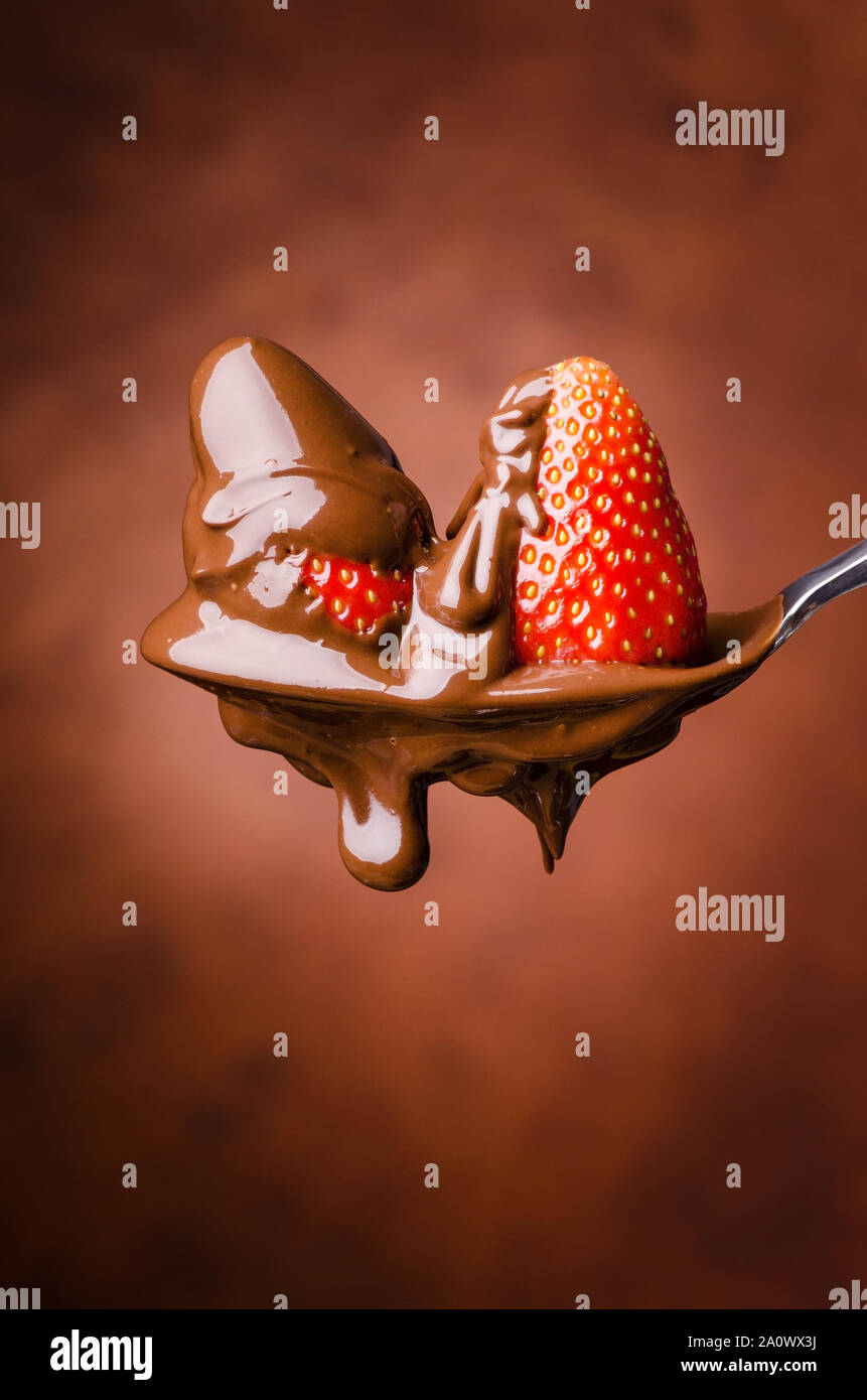 Un cucchiaio di isolati con fragole e cioccolato fondente fuso Foto Stock