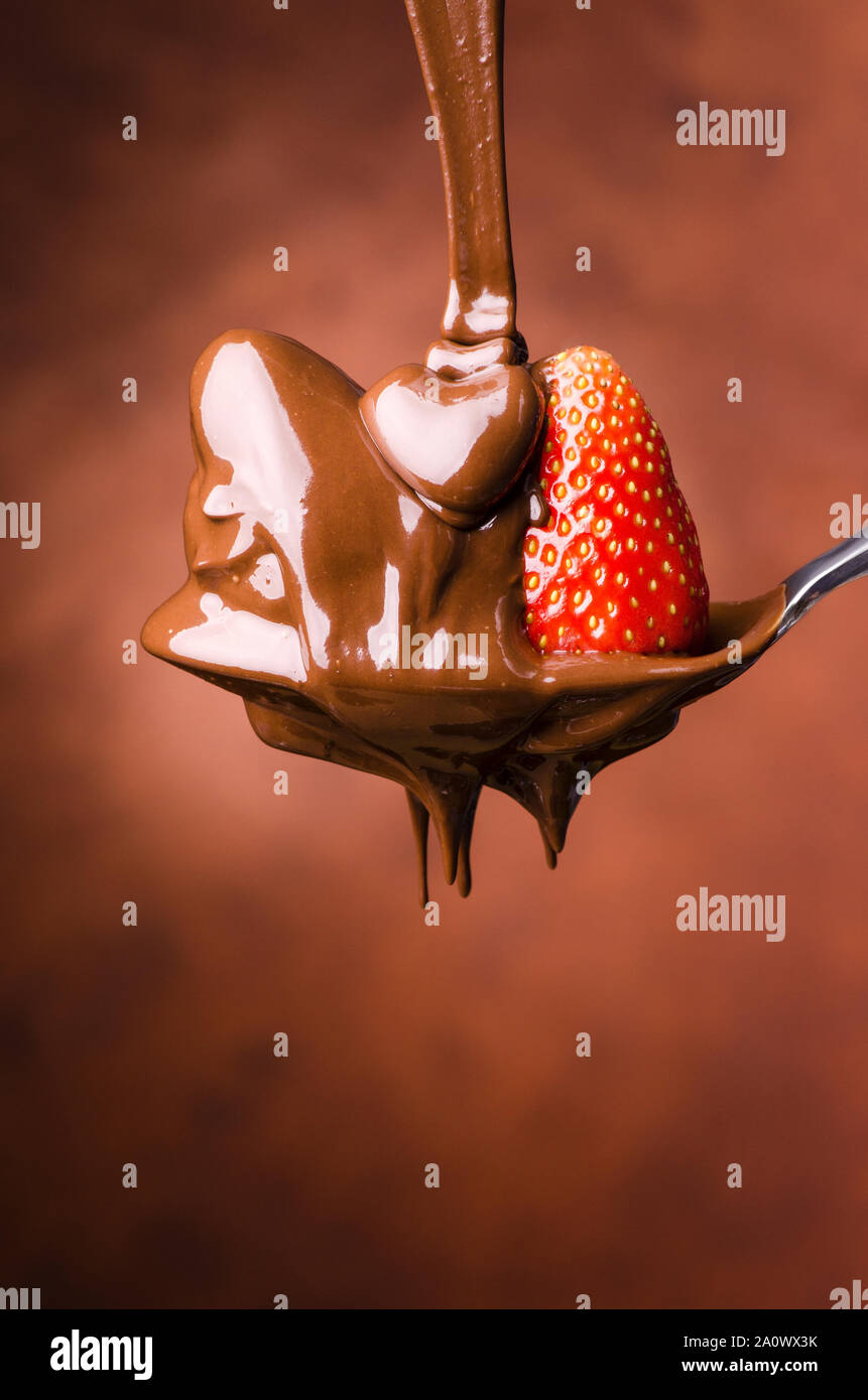 Un cucchiaio di isolati con fragole e cioccolato fondente fuso Foto Stock