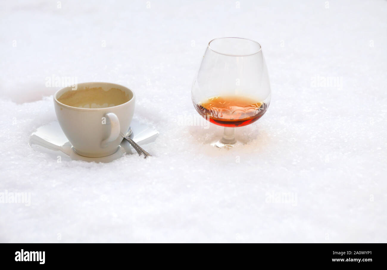 Caffè caldo e caldo cognac in neve fredda Foto Stock