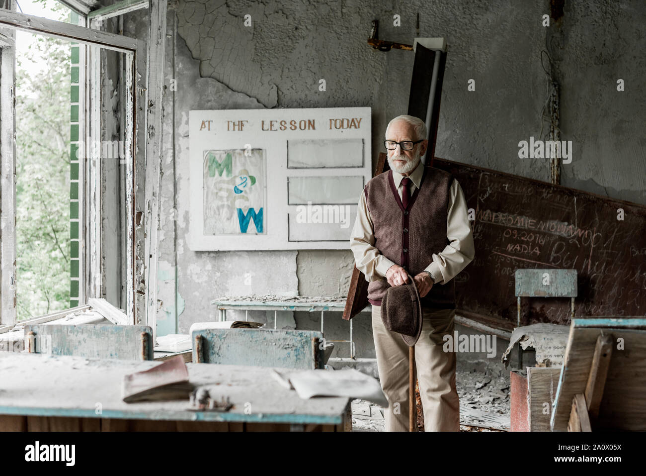 Messa a fuoco selettiva di pensionati uomo azienda hat mentre sta in piedi vicino a bordo con lettere Foto Stock