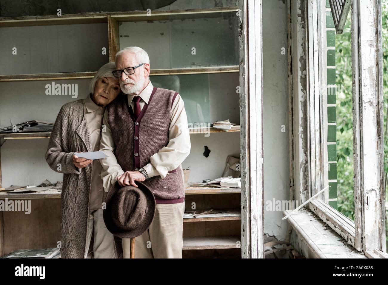 Ritirato la donna barbuta e il marito in piedi in aula danneggiata Foto Stock
