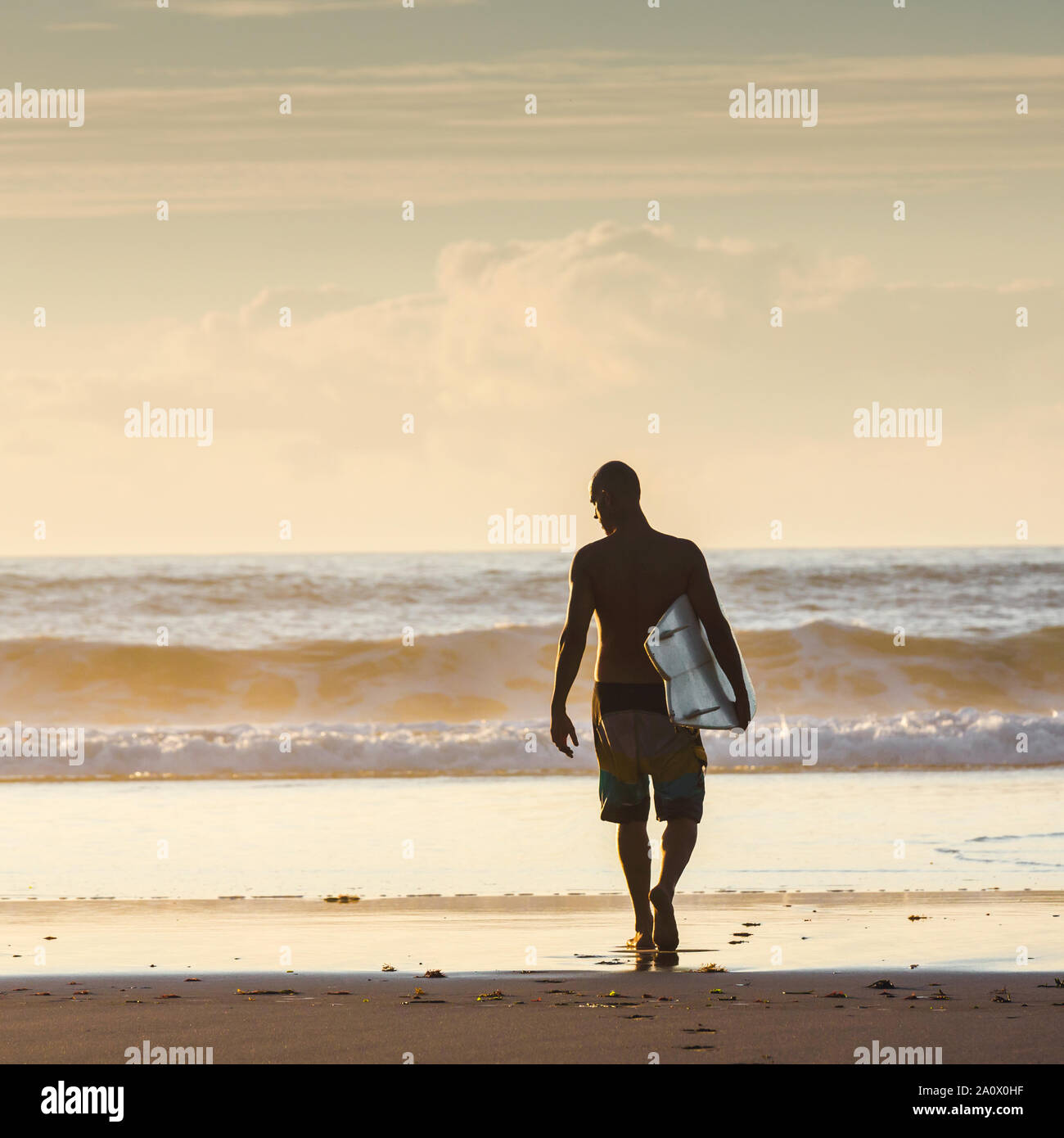 Surfer camminando sulle onde Foto Stock