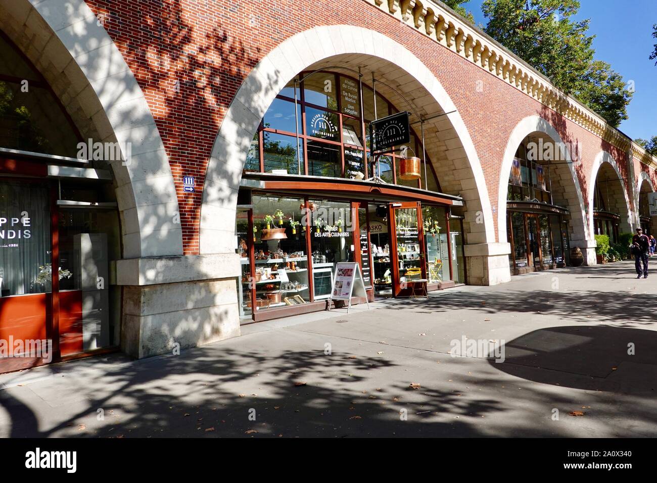 A livello di strada negozi sotto la Promenade Plantee, una verde a piedi nel dodicesimo arrondissement seguendo il vecchio Vincennes linea ferroviaria, Paris, Francia. Foto Stock