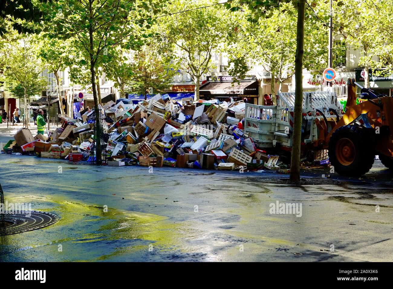 I rifiuti lasciati da Daumesnil street market essendo spinto in una pila per il clean-up sul boulevard de Reuilly nel dodicesimo arrondissement di Parigi, Francia. Foto Stock