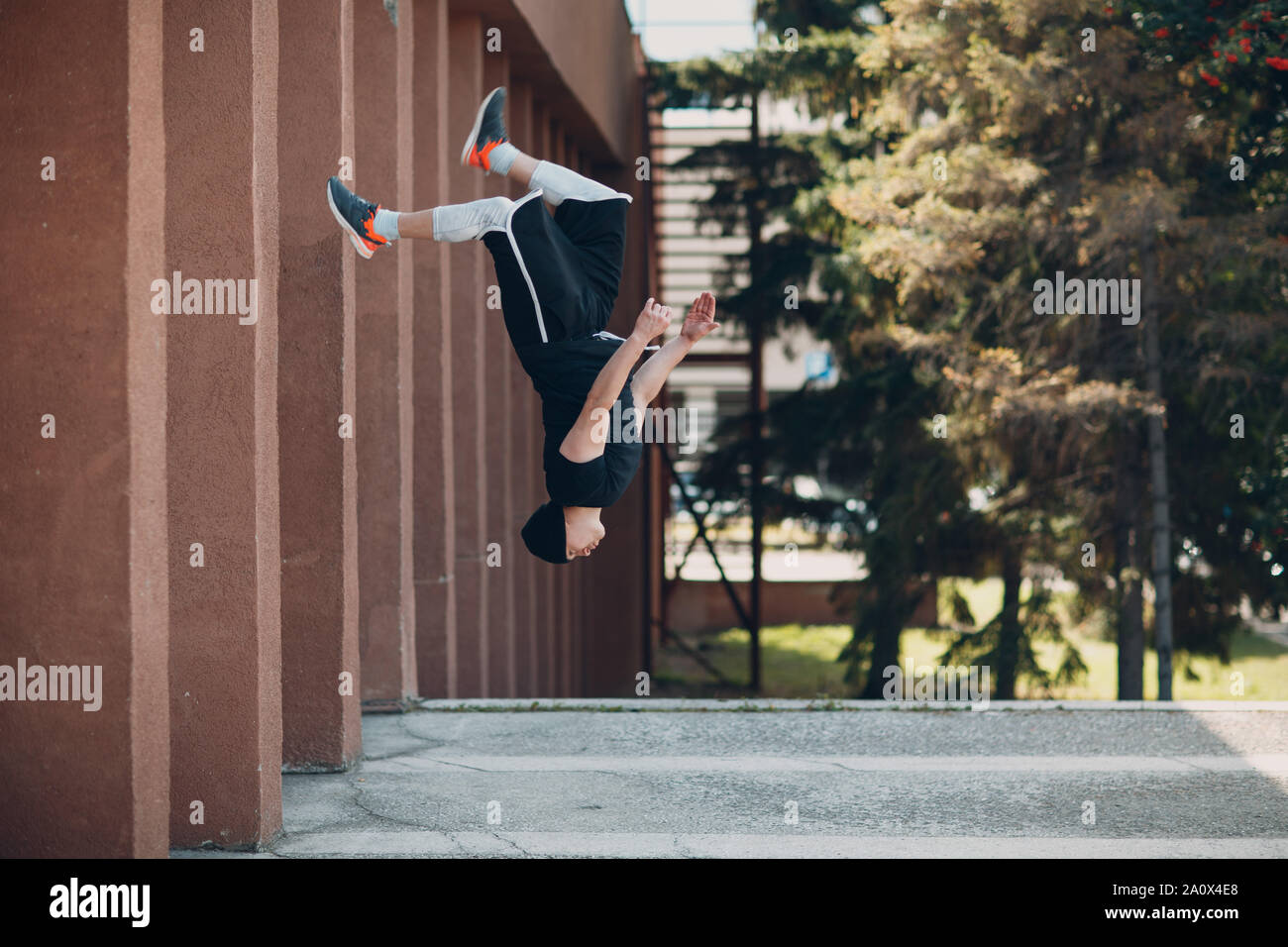 Parkour giovane uomo facendo acrobazie e trick flip jumping alta Foto Stock