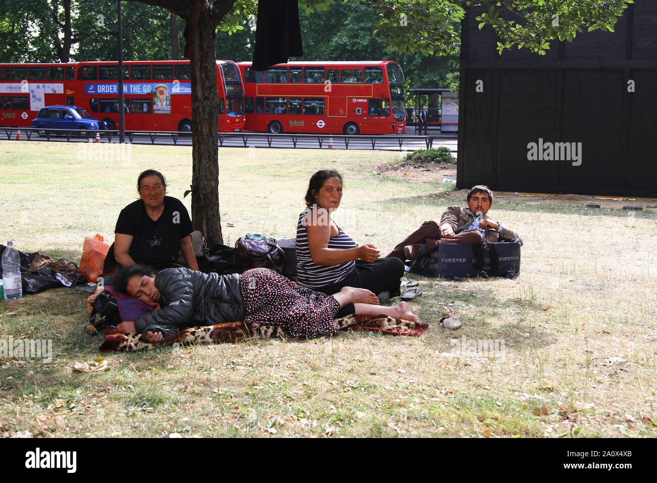 Senzatetto CAMP MIGRANTE IN PARK LANE, Mayfair, Londra cancellato dalla polizia ma il camp è stato lì dato che queste foto sono state scattate nel 2013. Due degli uomini nascondere le loro facce. Alcuni sostengono le loro mani per denaro. Un'ondata di criminalità nella zona di Mayfair è stato riportato. Questi la maggior parte bulgaro e rumeno camper muovere su e giù il PARK LANE A MARBLE ARCH frequentemente. A DEPORTARE traversine ruvida che sono cittadini UE è illegale. Campi di migranti. I migranti economici. VAGRANCY. VAGRANTS. VAGRANTS PER SCELTA. Foto Stock