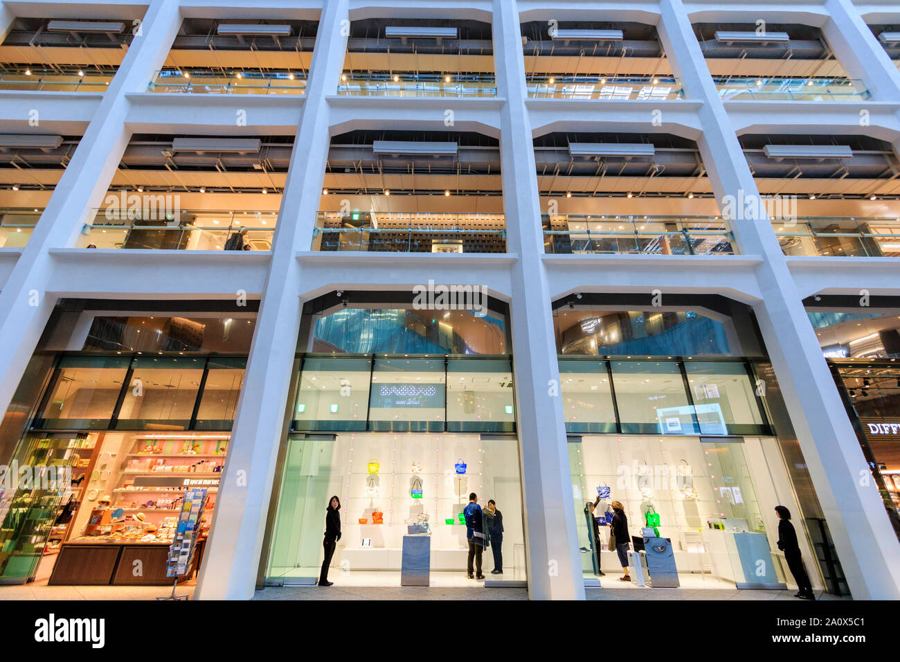 Tokyo, Marunouchi. KITTE building interior. L'atrio triangolare, guardando verso l'alto dal piano terra, con Issey Miyake, stilista giapponese store. Foto Stock