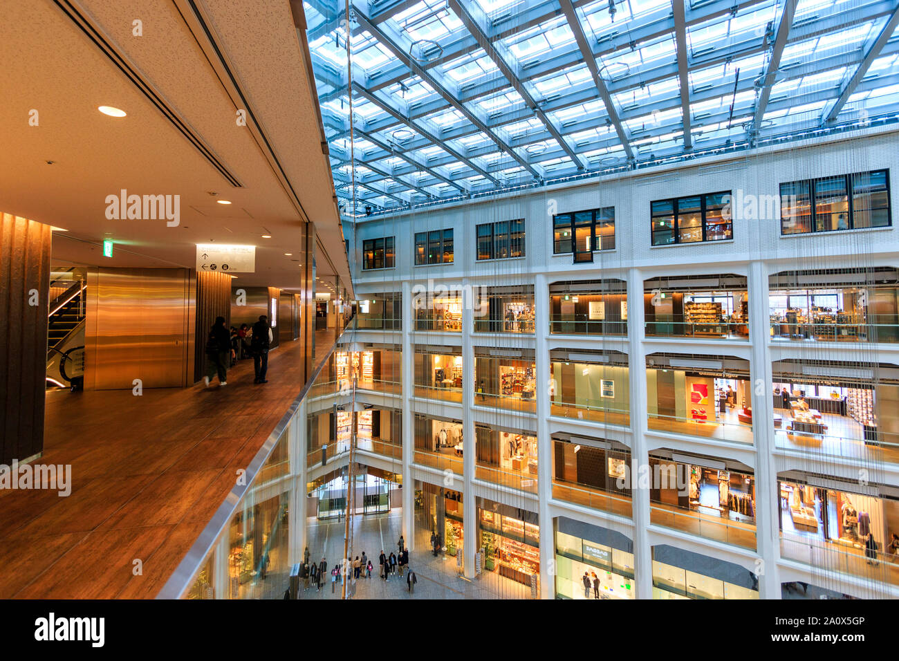 Tokyo, Marunouchi. JP KITTE tower building interior. Vista d'angolo dell'atrio triangolare, corridoio, negozi e tetto. Ore diurne. Persone. Foto Stock