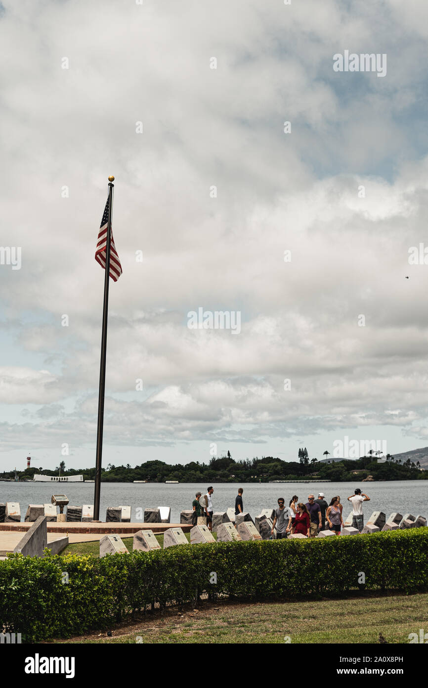 Pearl Harbor, Hawaii - 23 agosto 2019: una bandiera americana sorvolano visitatori presso il porto di perla storico centro visitatori con la USS Arizona Memori Foto Stock