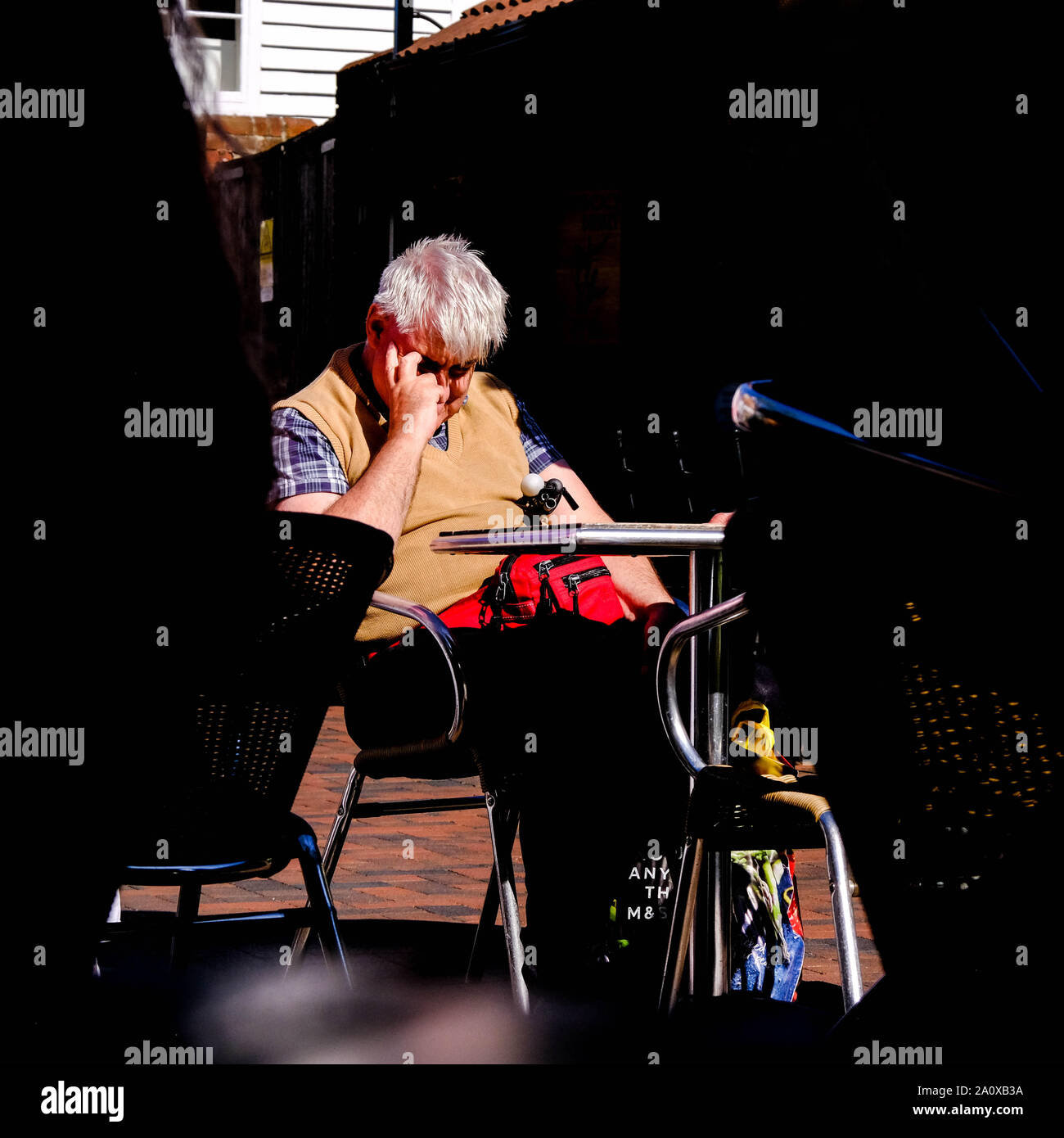 Poco lungimirante o cieco seduto da solo su una sedia di vimini in attesa e di pensiero Foto Stock