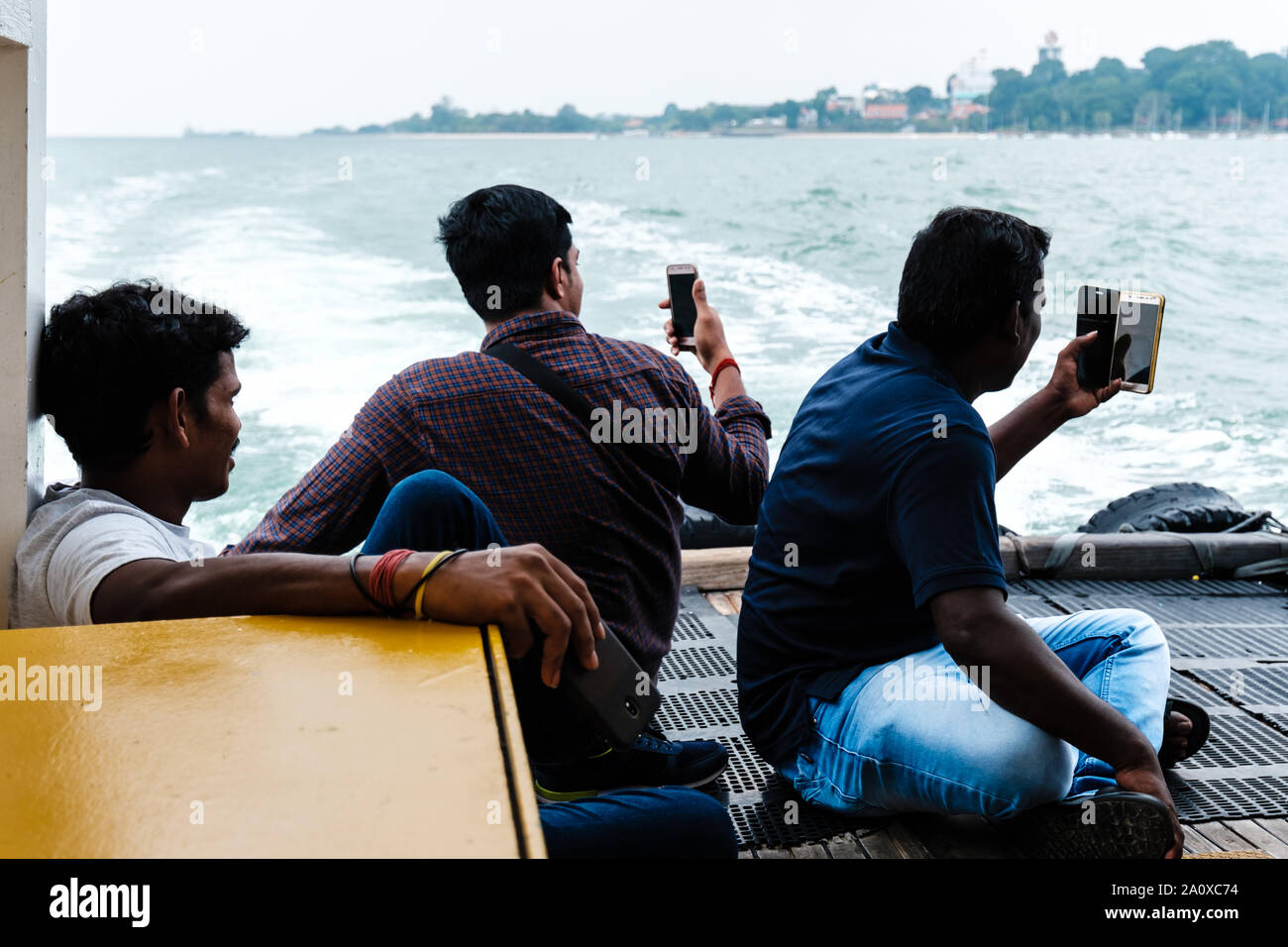 Singapore-09 agosto 2019:uomo indiano sul traghetto e scattare foto Foto Stock