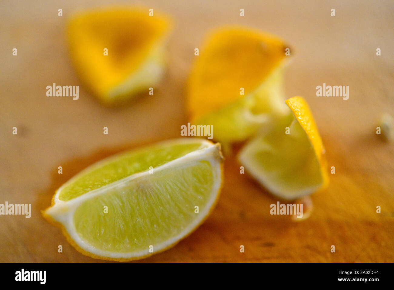 Limoni Limette maturi tagliati e schiacciato sul tagliere di legno Foto Stock