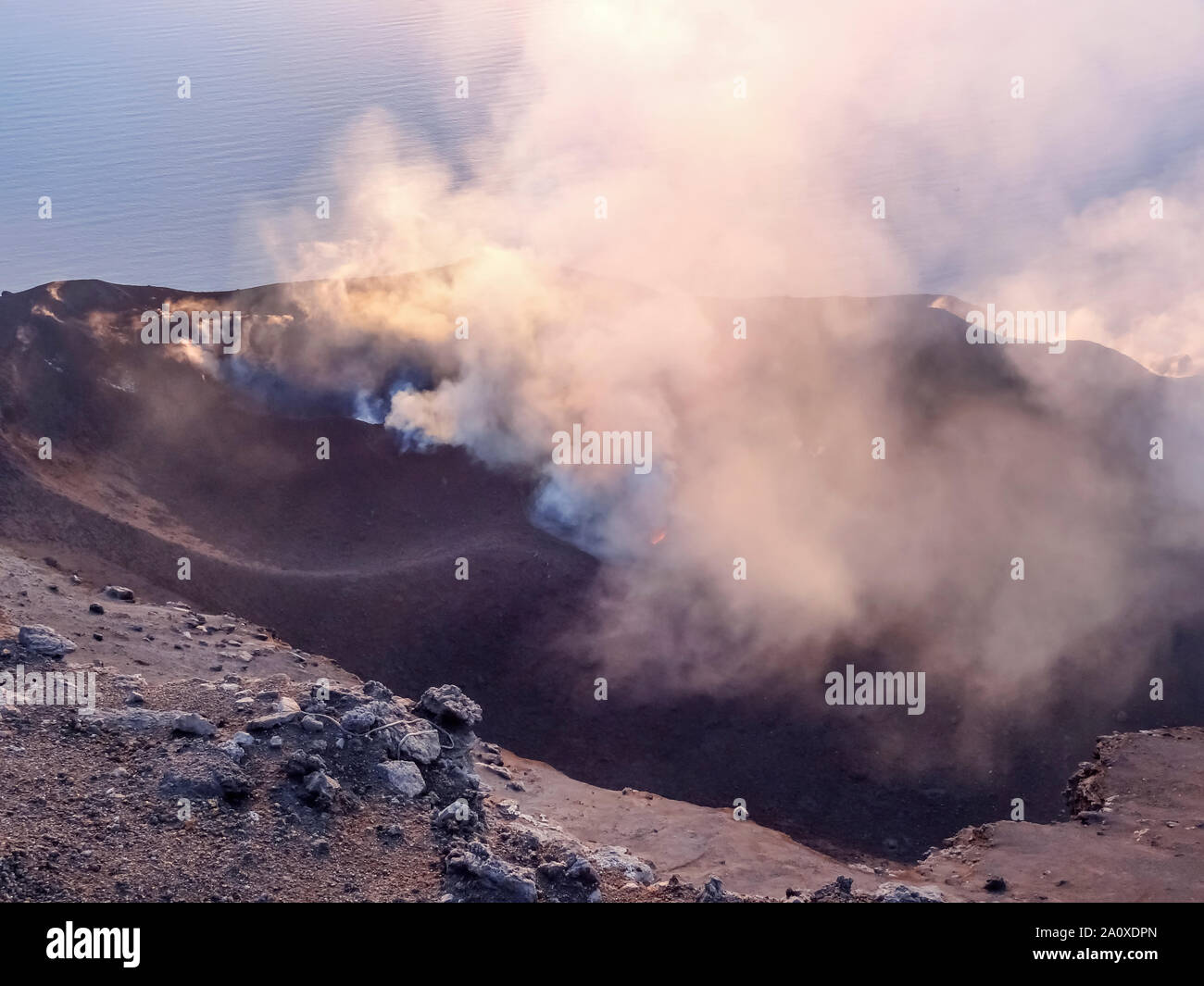 Fumoso scenario del cratere di vulcano Stromboli vicino la Sicilia al tempo di sera Foto Stock