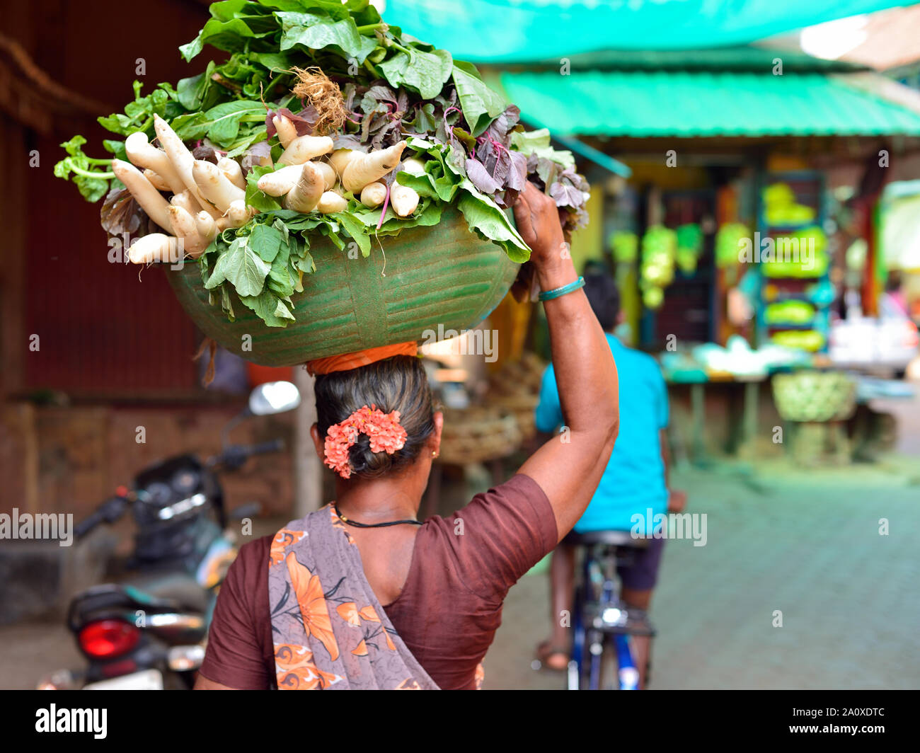 La donna sta portando le verdure nel cestello sulla testa Gokarna, il Karnataka. Foto Stock
