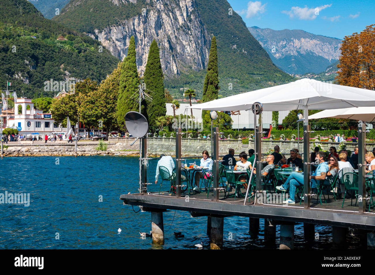 Persone di mangiare al ristorante sulla piattaforma sopra il lago, il Lago di Garda, Riva del Garda Trentino, Alto Adige, Italia settentrionale Foto Stock