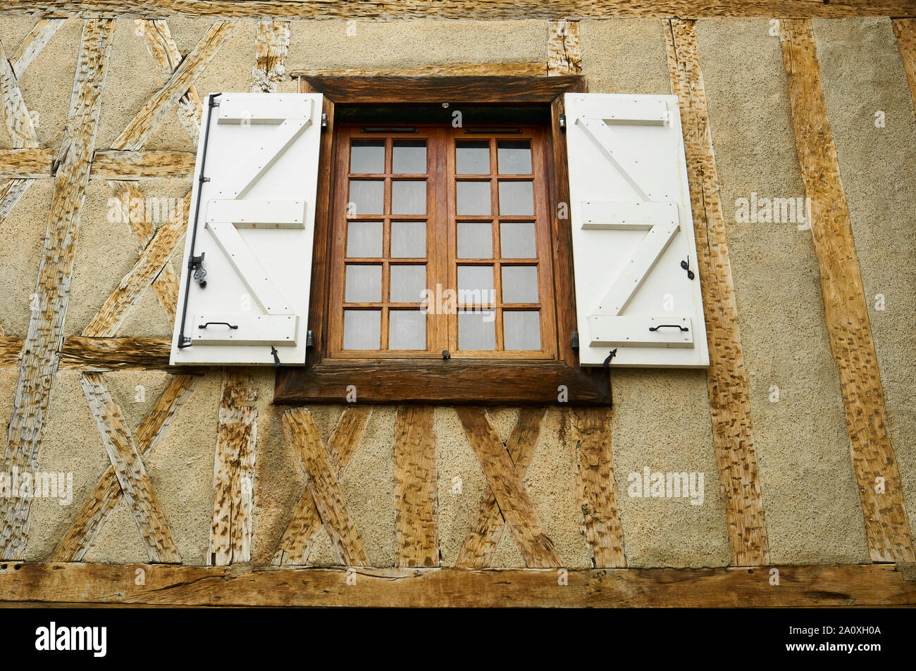 Finestra di legno con persiane bianche in un mezzo in legno architettura tradizionale casa in Saint-Lizier (Saint-Girons, Ariège, Occitanie, Pirenei, Francia) Foto Stock