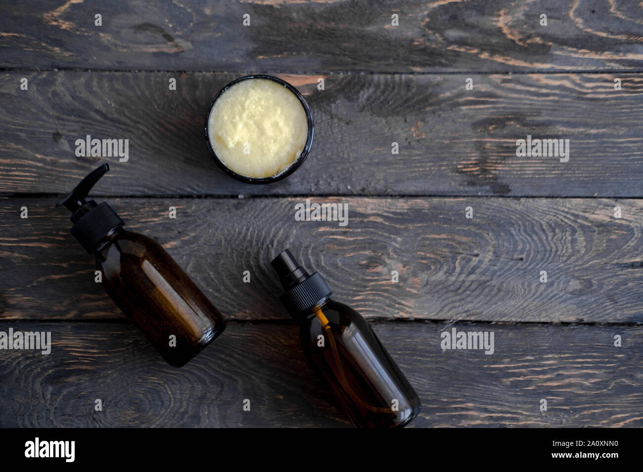 Il marrone scuro vetro flaconi cosmetici sul tavolo di legno, overhead. Prodotti di bellezza concetto. Closeup, spazio di copia Foto Stock