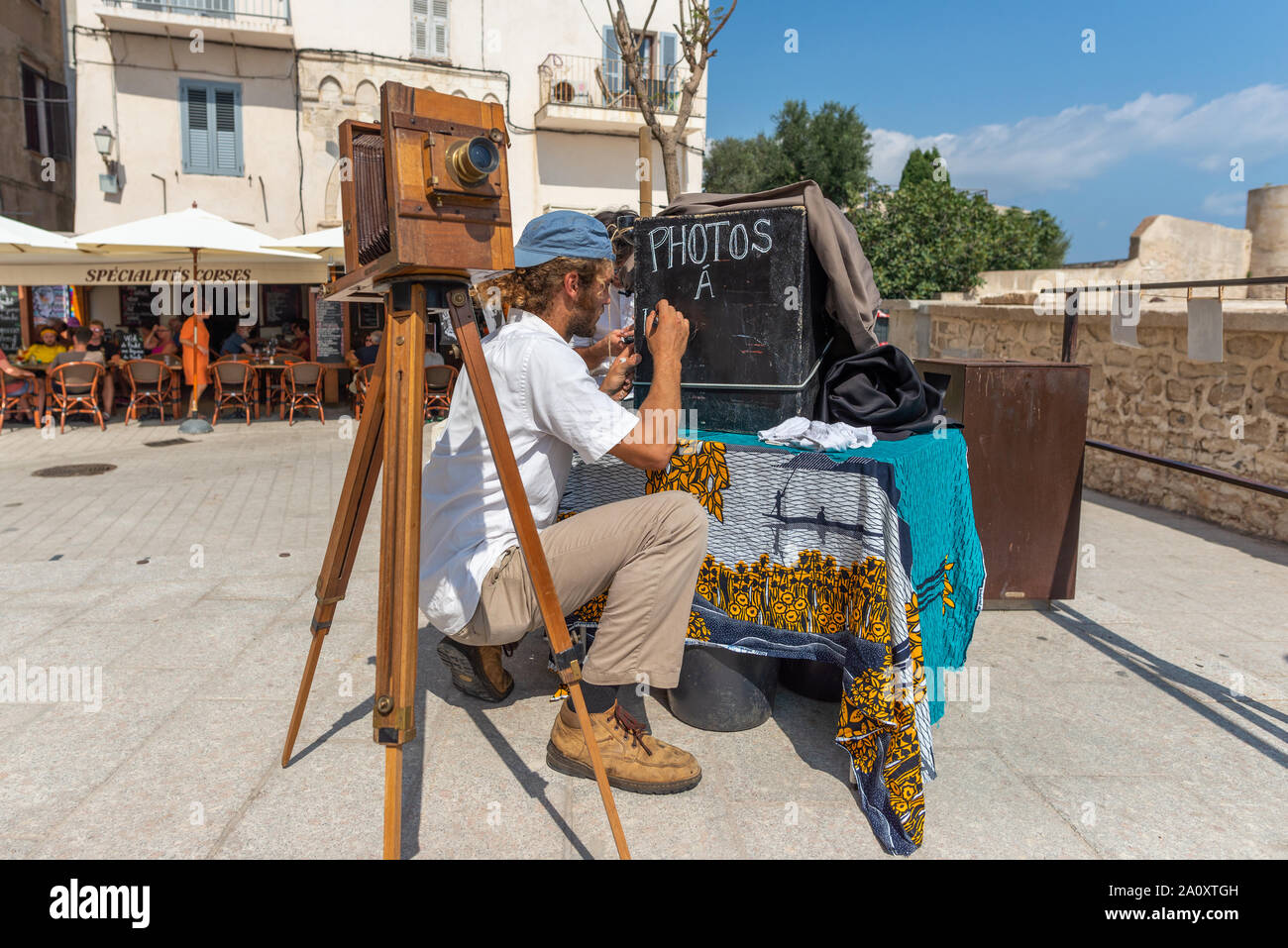 Bonifacio, Corsica, Francia - Sep 19, 2019: Maschio fotografo utilizzando una fotocamera vintage nella città vecchia. Prese durante un pomeriggio d'estate. Foto Stock