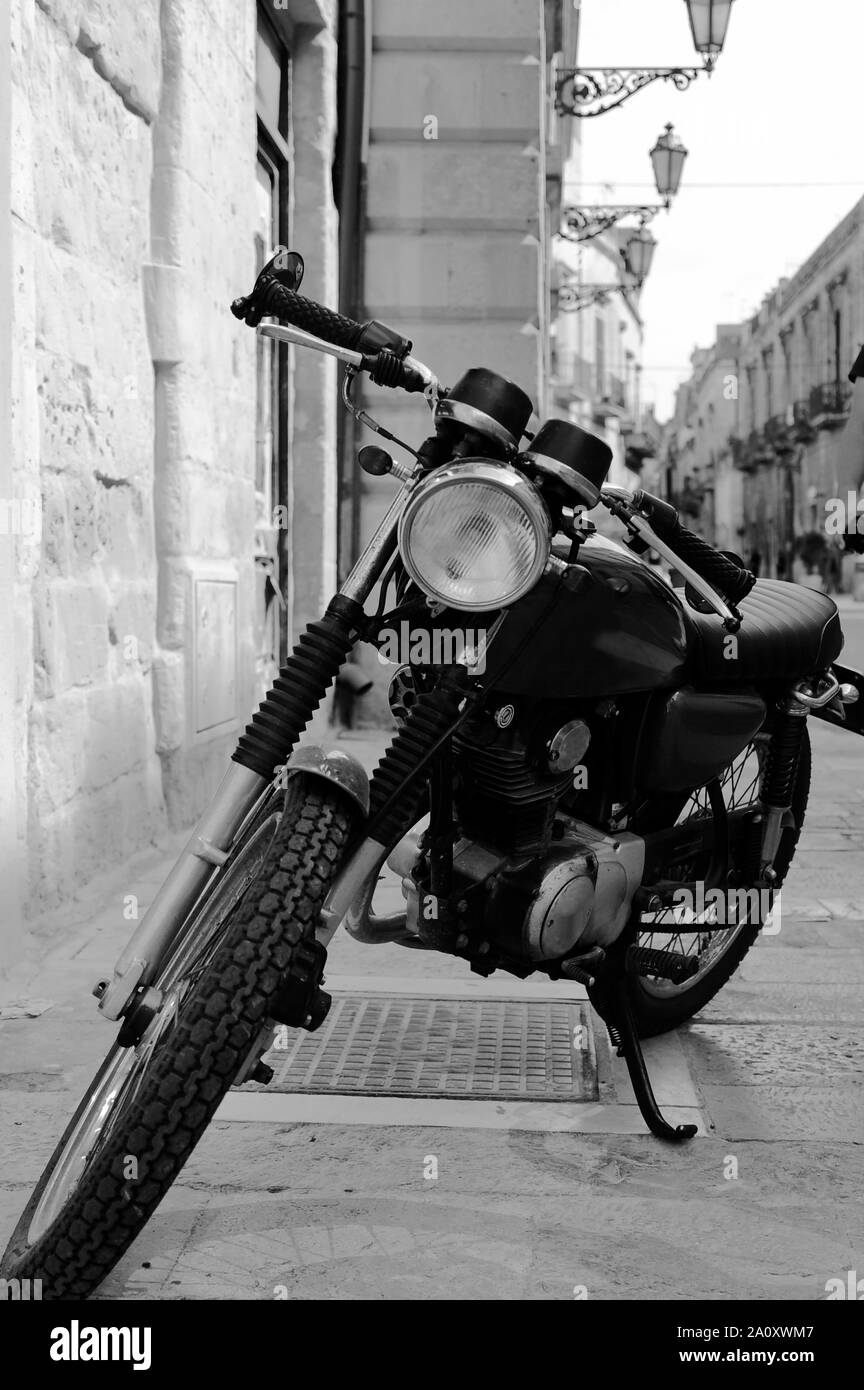Vintage moto nero in piedi in strada della vecchia città italiana. Lecce, Puglia, Italia Foto Stock