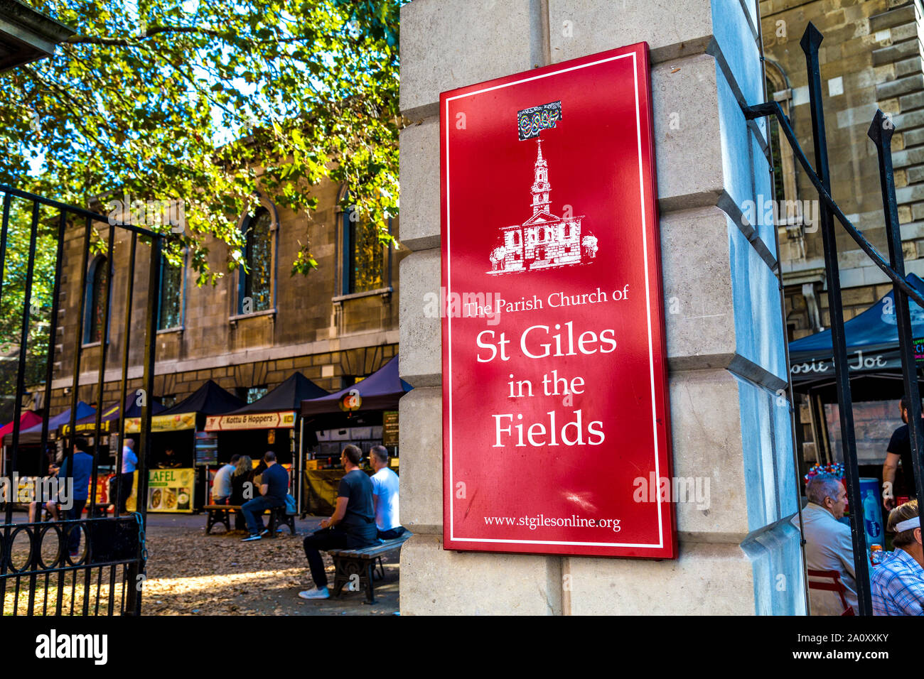 Cancello per St Giles nei campi chiesa in Tottenham Court Road e il mercato alimentare nel sagrato, London, Regno Unito Foto Stock